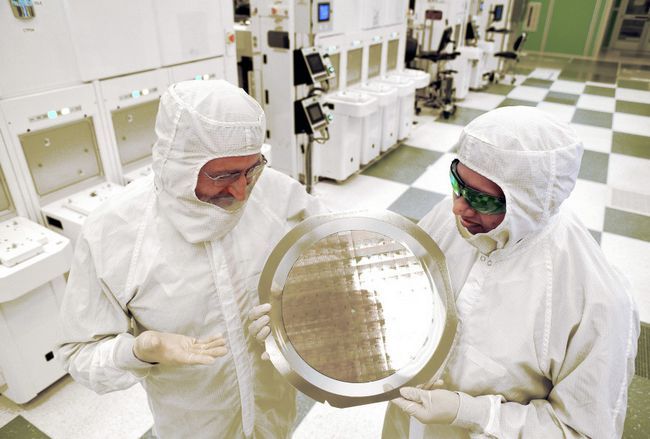 SUNY Colegio de Nanotecnología e Ingeniería's Michael Liehr, left, and IBM's Bala Haranand look at wafer comprised of 7nm chips on Thursday, July 2, 2015, in a NFX clean room Albany. Several 7nm chips at SUNY Poly CNSE on Thursday in Albany. (Darryl Bautista/Feature Photo Service for IBM)